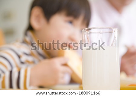 Japanese boy drinking a glass of milk and eating a toast