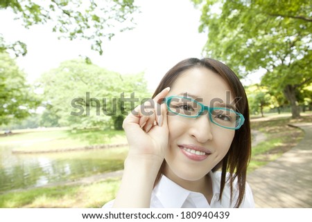 Japanese Office lady with a smile adjusting glasses