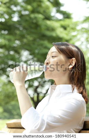 Japanese office lady drinking mineral water in the park