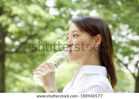 office lady drinking mineral water in the park