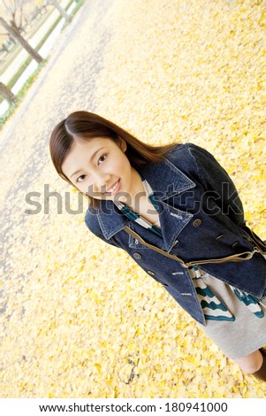 Japanese woman who walks on the street lined with the ginkgo tree