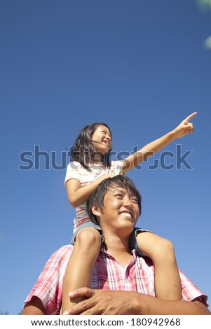 Japanese Father giving piggyback ride to daughter