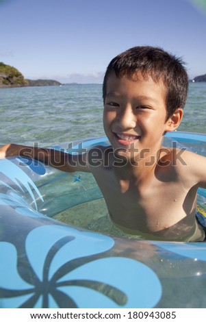 Japanese boy playing with a swimming float