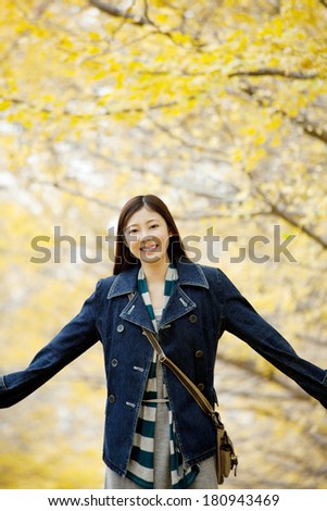 Japanese woman walking on the street lined with the ginkgo tree
