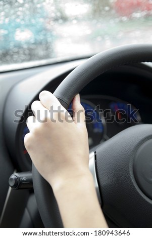 Hand of a Japanese woman behind the wheel of car