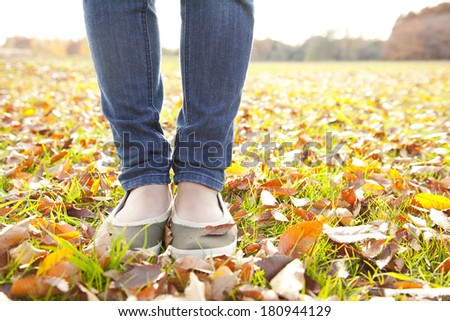 feet of a Japanese woman standing on a pile of leaves