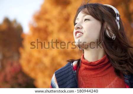 Japanese woman smiling and listening to music