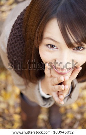 Japanese woman looking up while covering her face with her hands