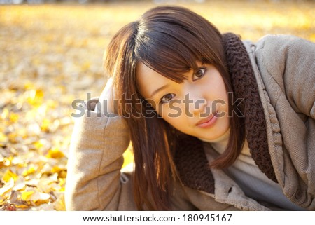 woman playing on a pile of leaves,