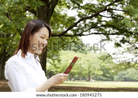 office lady checking the mobile email in the park