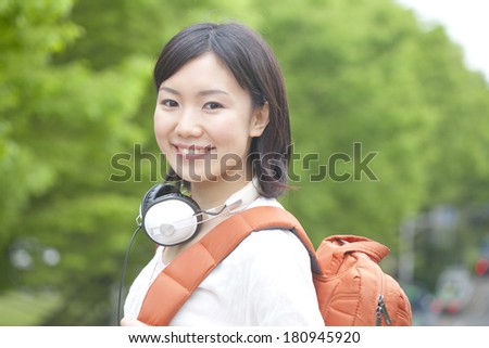 A Japanese student smiling while listening to music
