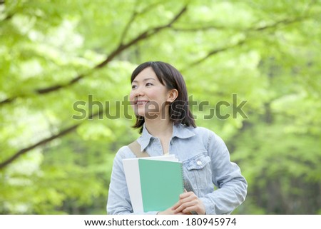 Japanese student smiling surrounded by nature,