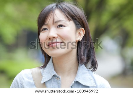 A Japanese student smiling and staring into far distance,