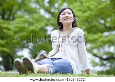 Students staring into blank space while sitting on a patch of grass,