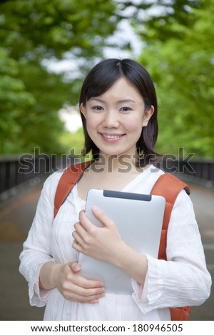 A Japanese student smiling at his tablet PC,