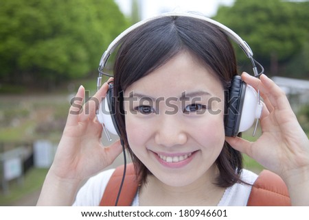 A Japanese student smiling while listening to music