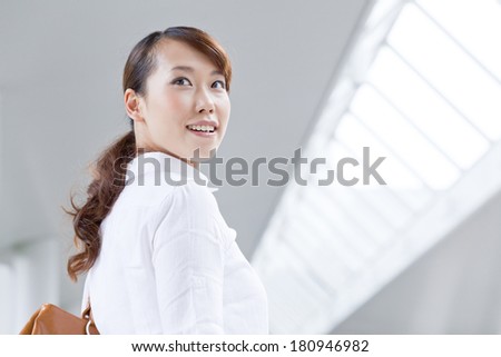A Japanese office lady looking back with a smile,