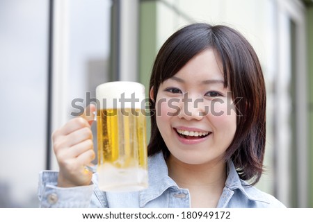 A Japanese student smiling while holding a mug,