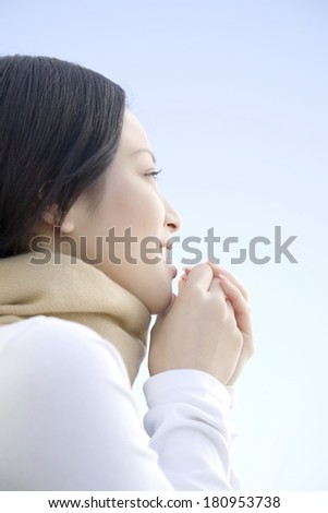 Japanese woman blowing warm air on her hands