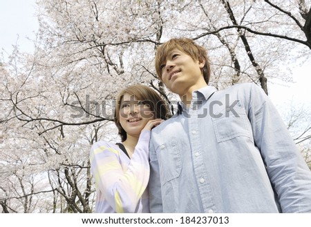 Couple snuggles up under cherry trees.