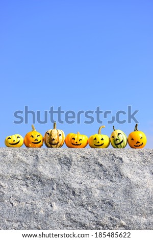 Jack-o-lanterns sitting on top of stone with blue background