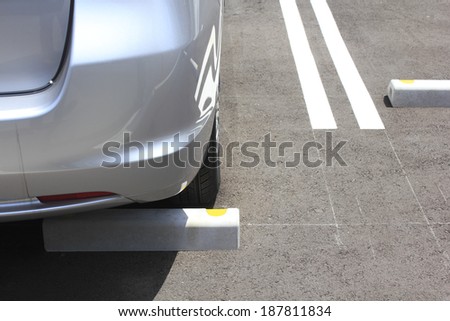 close up of silver car parked in parking spot