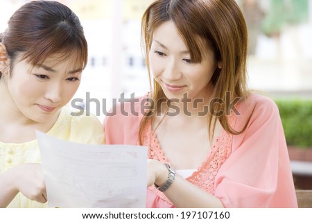 Two Women Looking For Shops On The Map