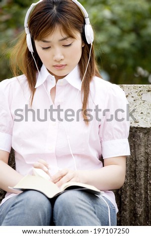 Woman Reading A Book While Listening To Music
