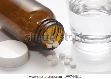 Glass Of Water And The Medicine Bottle With Tablets