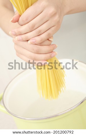 a hand grabbing pasta