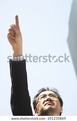 Businessman pointing at the sky