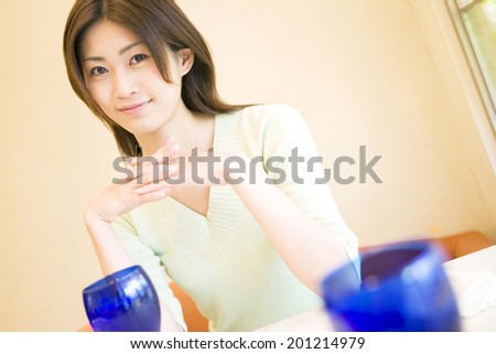 smiling woman touching elbow on the table
