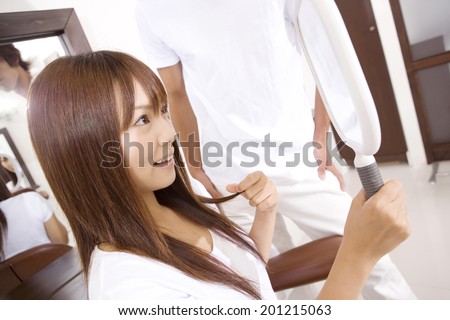 Woman looking in the mirror at the hair salon