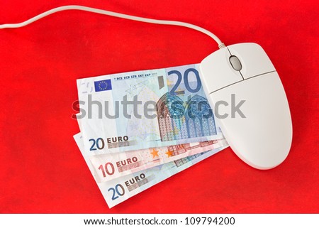 Making money online concept. Computer mouse and money on red background.