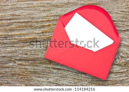 Red envelope with blank letter on wooden background