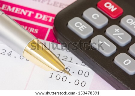 Metal pen, calculator and payslip with monthly wage