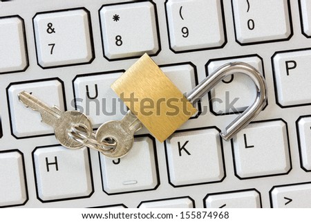 Unlocked padlock with a keys on the computer keyboard