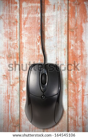 Black computer  mouse on the old wooden planks background