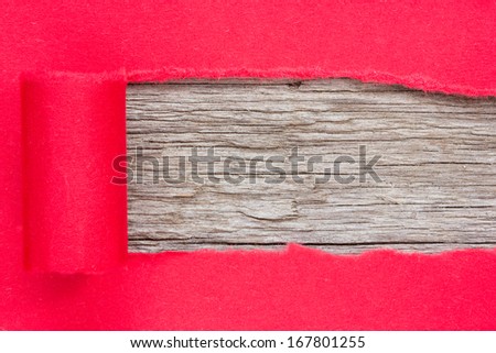 Red paper torn to reveal wooden panel for copy space