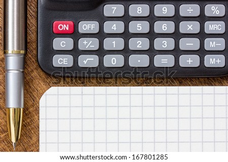 Adding up figures concept with calculator, pen and notepad on the table