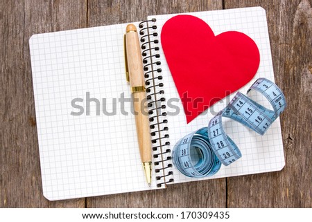 Set your goals . Measure tape,pen and paper heart  on the notebook.