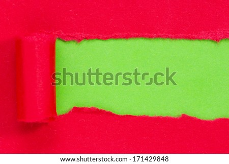 Red paper torn to reveal green panel ideal for copy space