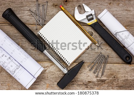 Tools , twisted technical drawing and blank notebook