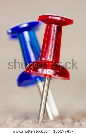 Red and blue pushpins on the wooden background