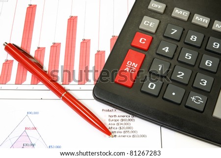 calculator and red pen over a business chart.