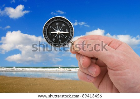 travel concept. human hand with compass on the sea background