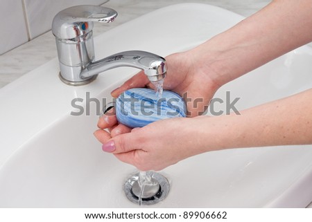 human hands being washed under stream of pure water