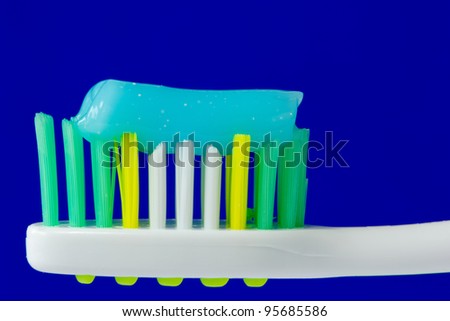 toothbrush with toothpaste isolated on blue background