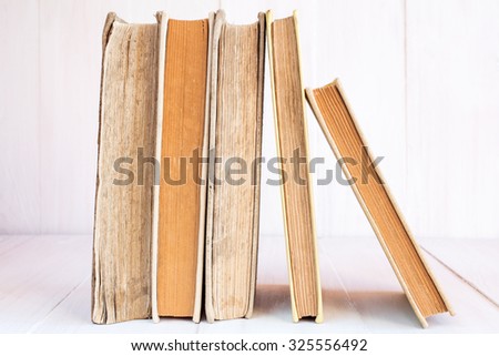 Old books in a row on wooden background