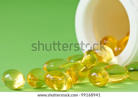pill bottle with yellow pills on green background